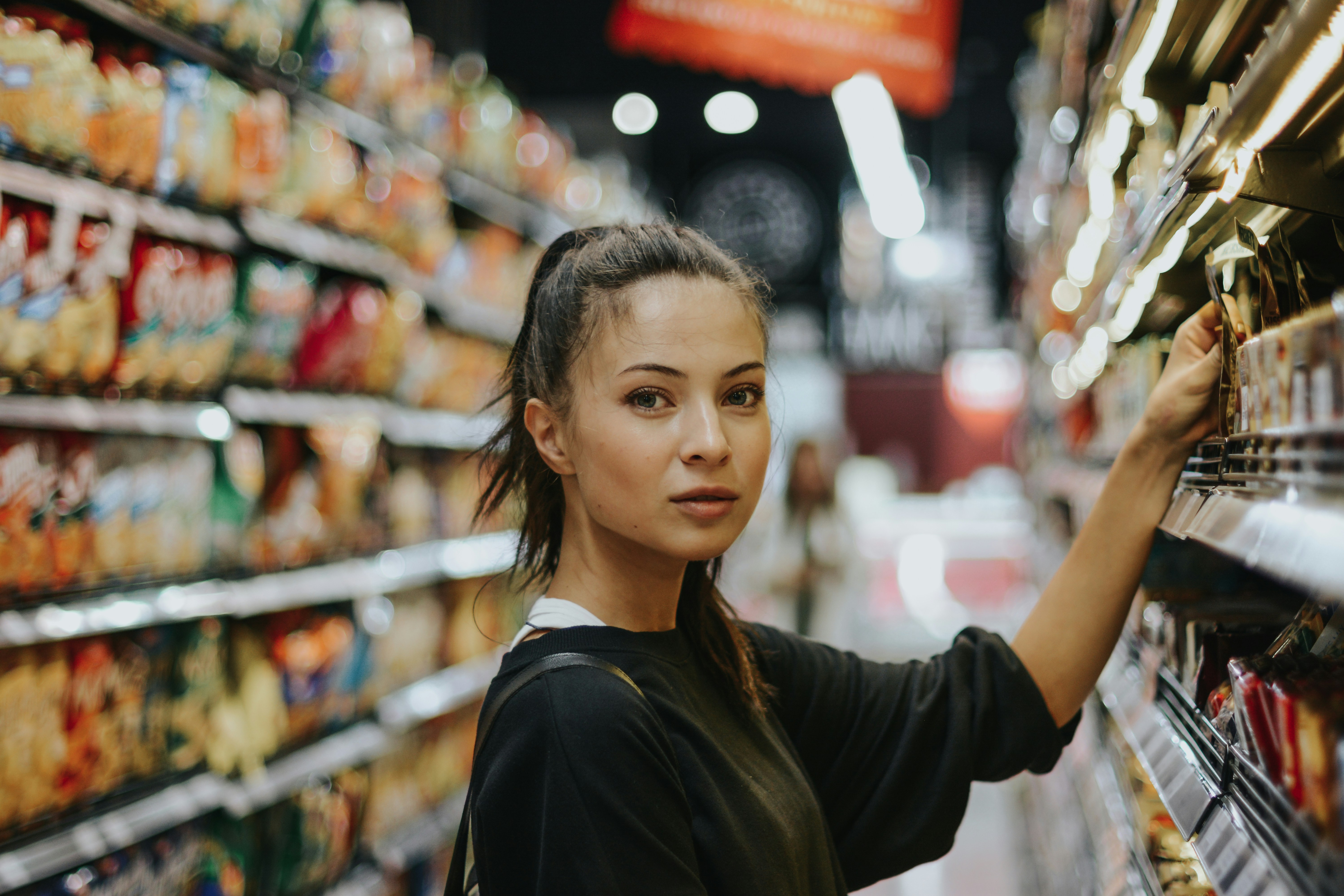 Consumidor seleccionando productos de marca propia en el anaquel de un supermercado